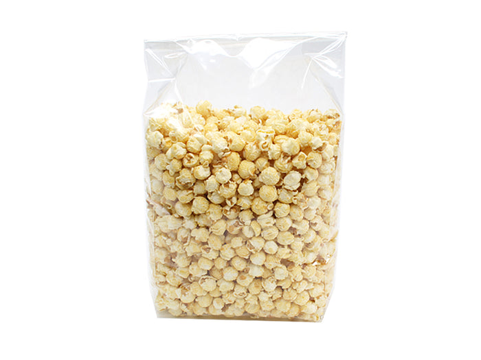 Høj klar pose med svejset flad bund, fyldt til randen med lyse gule kuglepopcorn